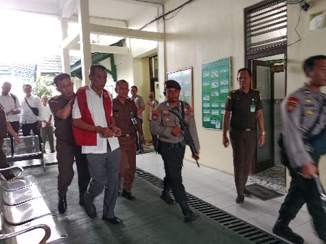 DIKAWAL : Terdakwa Madi Goening Sius terlihat dikawal petugas Kejaksaan Negeri Palangka Raya dan pihak kepolisian usai menjalani persidangan dengan agenda putusan, di PN Palangka Raya, Senin (26/6/2023). (foto:ard)