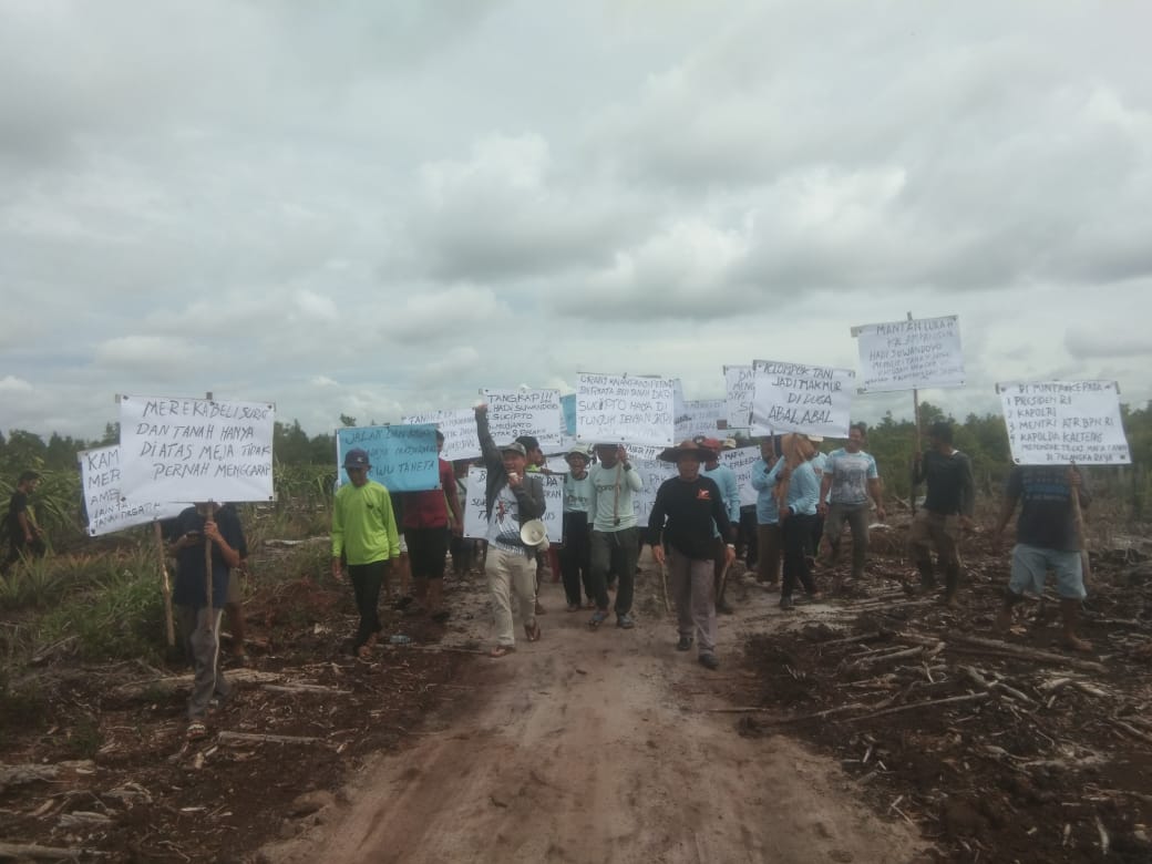 AKSI DAMAI : Anggota Kelompok Tani Lewu Taheta bersama pendampingnya Men Gumpul melakukan aksi damai, di Lokasi Lahan, Rabu (19/6/2024). (foto:ardi)