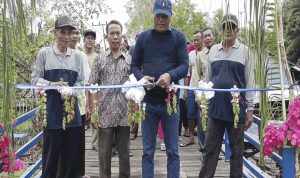 PERESMIAN : Anggota DPRD Kabupaten Kapuas, Saferaniansyah, meresmikan jembatan Handel Saka Lindung, ditandai dengan pemotongan pita, Senin (21/10/2024). (foto: ist)