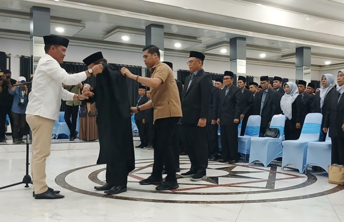 Gubernur Kalteng, Agustiar Sabran memasangkan baju toga kepada Ketua Dewan Hakim MTQH ke-XXXIII Tingkat Provinsi Kalteng tahun 2025 (Foto : Ist)